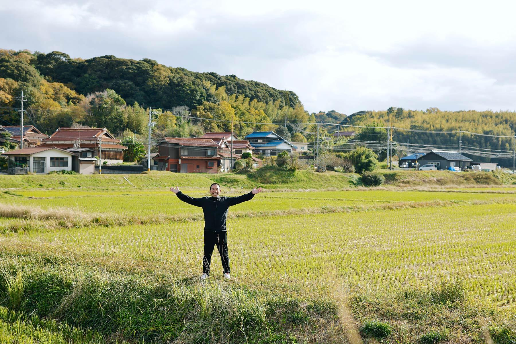 酒蔵の隣に広がる自営田に立つ永山さ