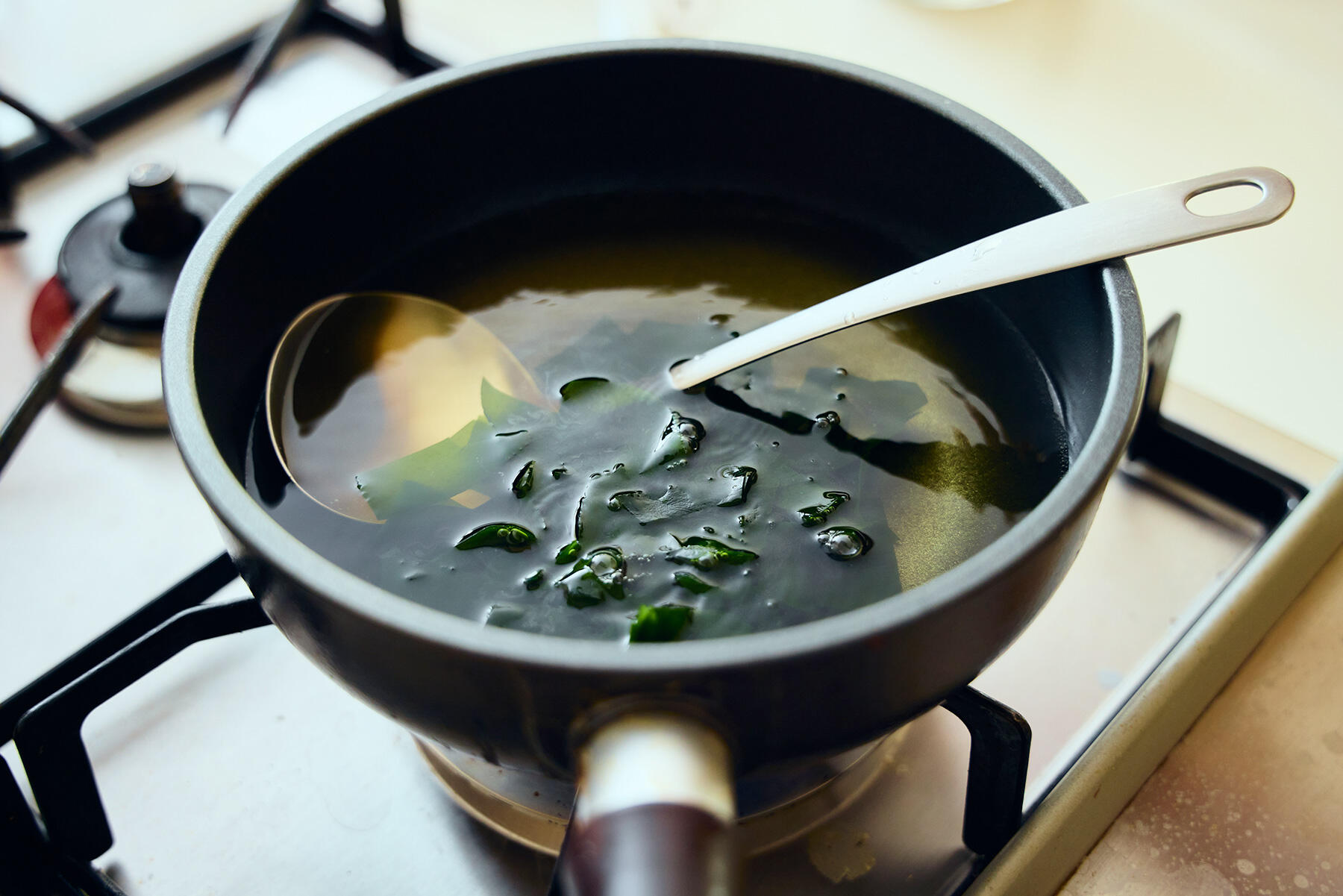 だしにわかめを加える