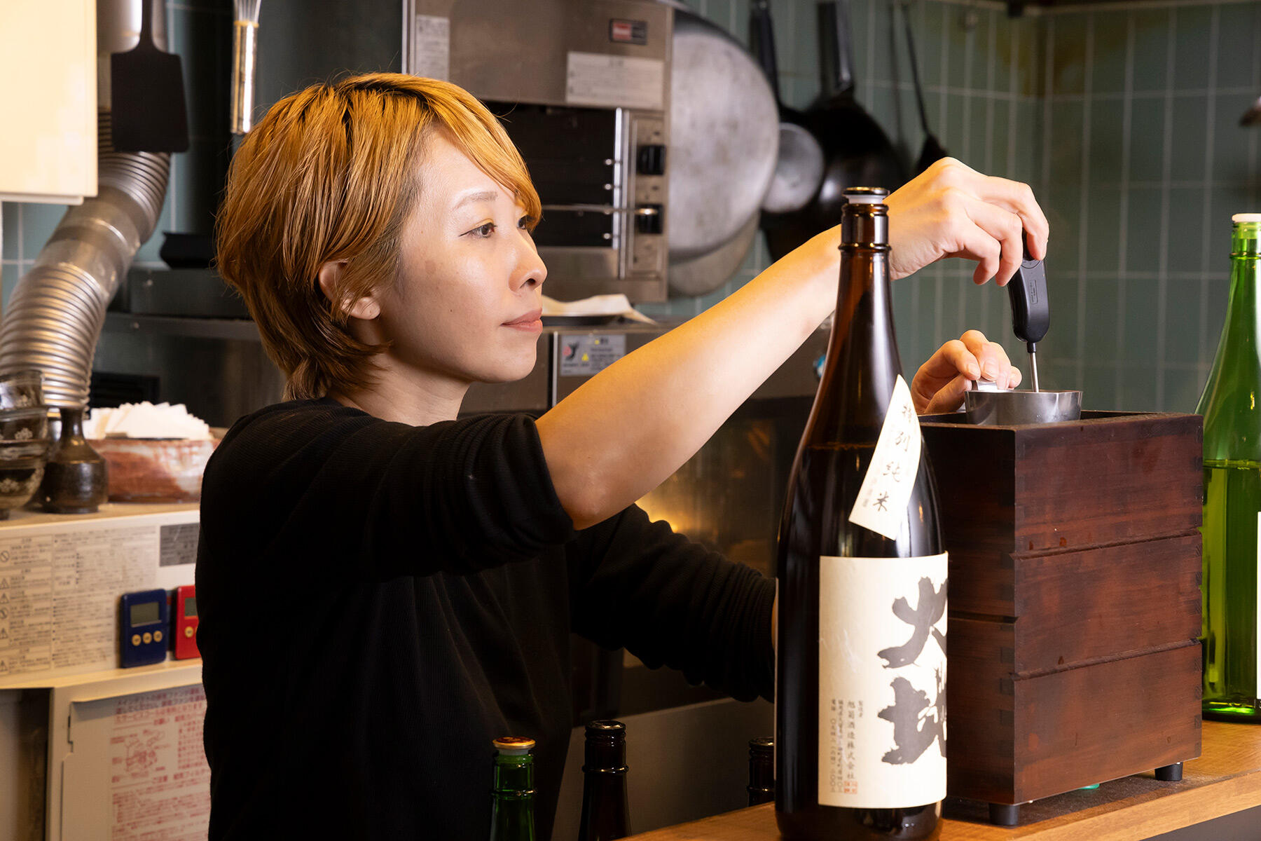 燗酒をつける岩間さん