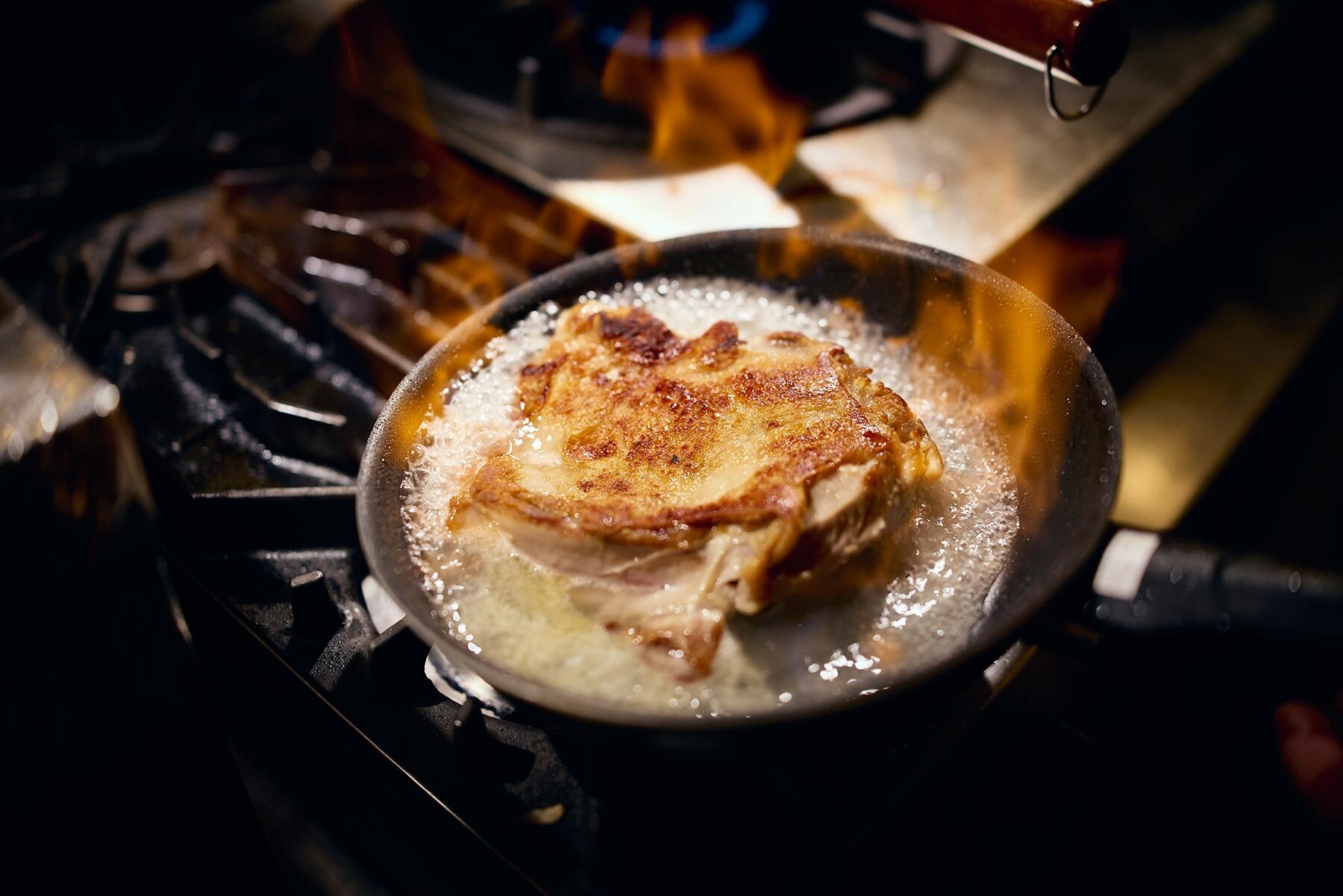 鶏肉を返し、酒でフランベする