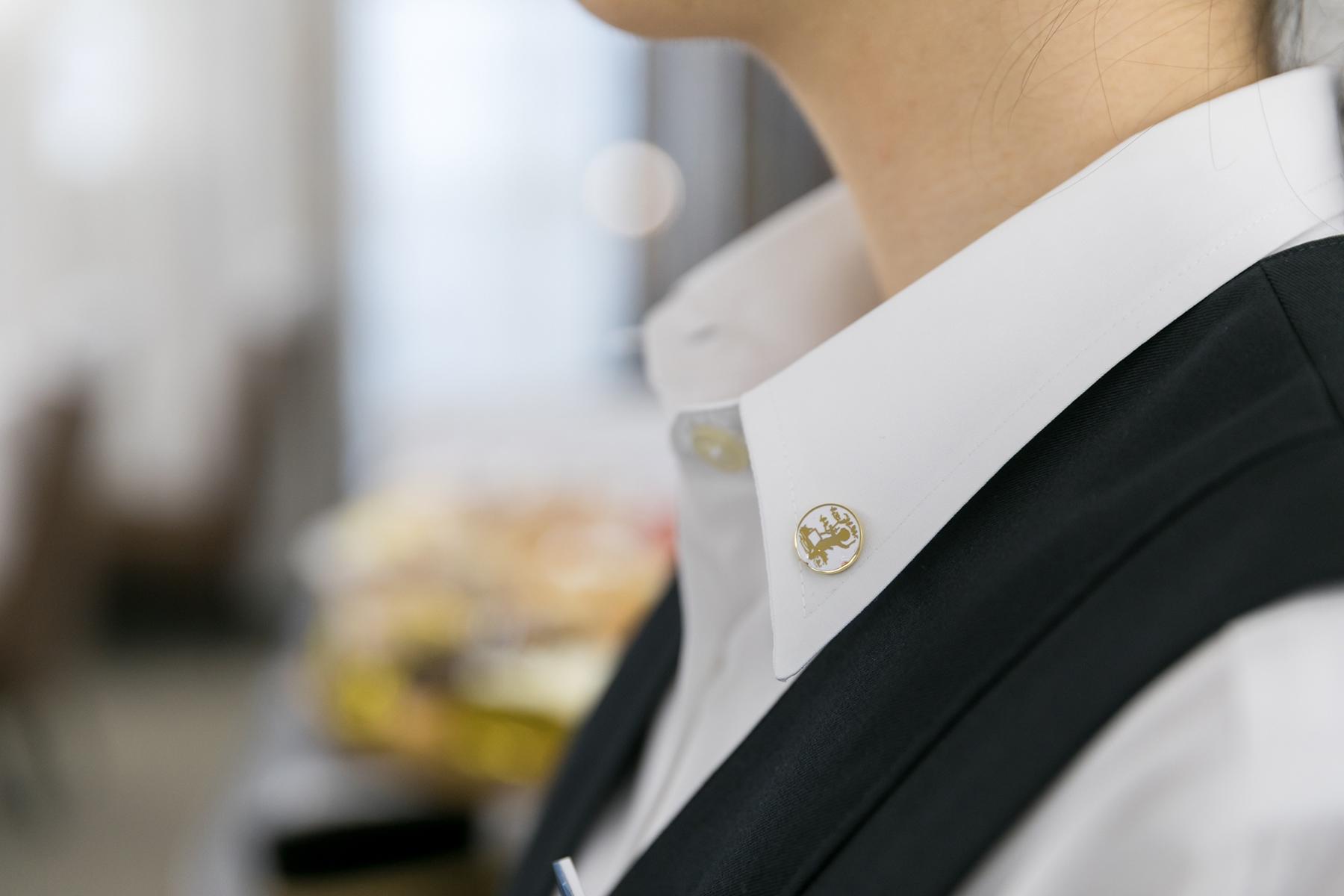 襟元の社員証のピンバッジ