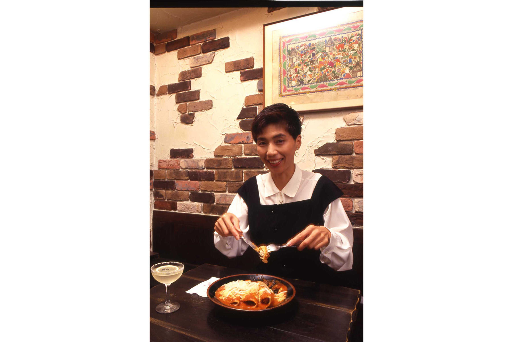 完成したエンチラーダに庄野さんは舌鼓。「初めはソースのピリッとした味を舌に感じるけれど、トルティージャや中の具と合わせて食べると実においしいですね」。