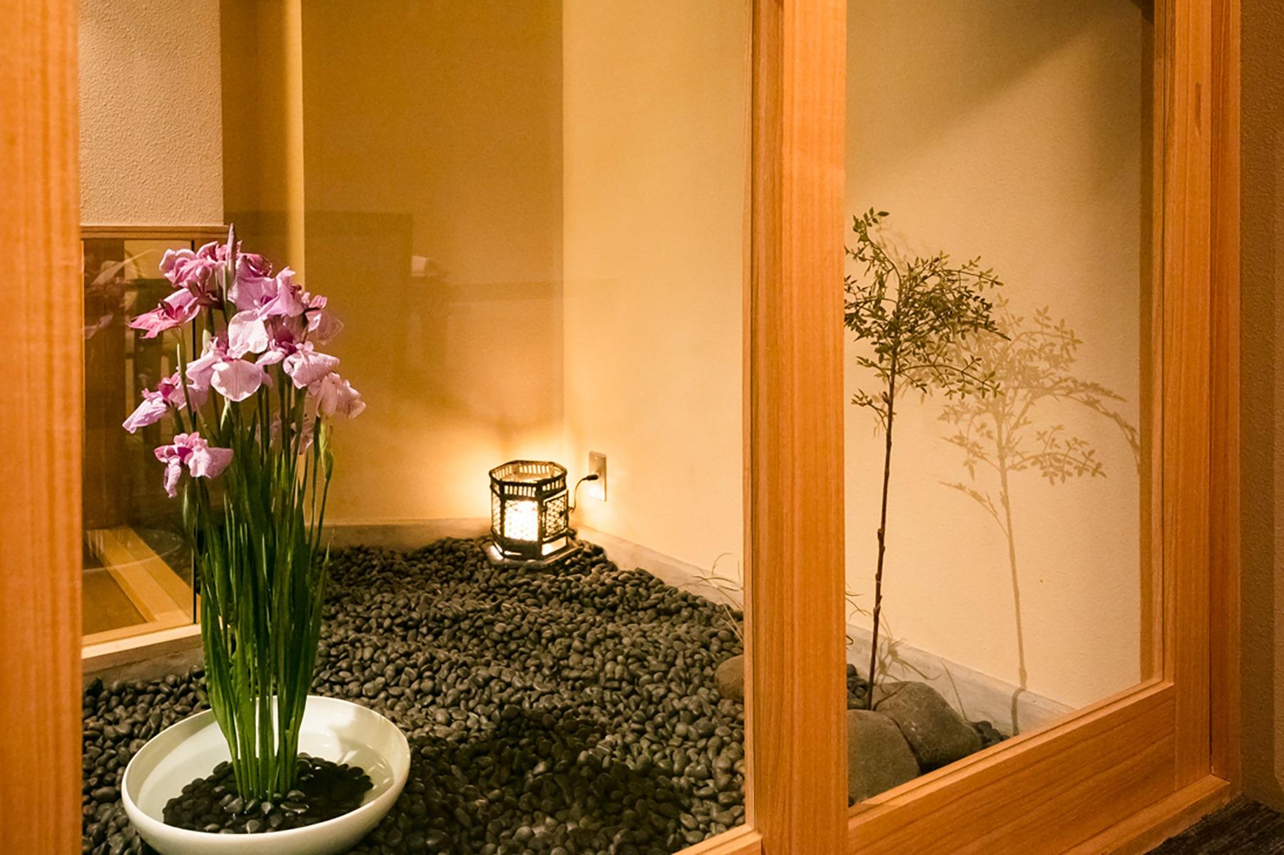 個室から坪庭を眺める。季節の花がさりげなく活けられている。