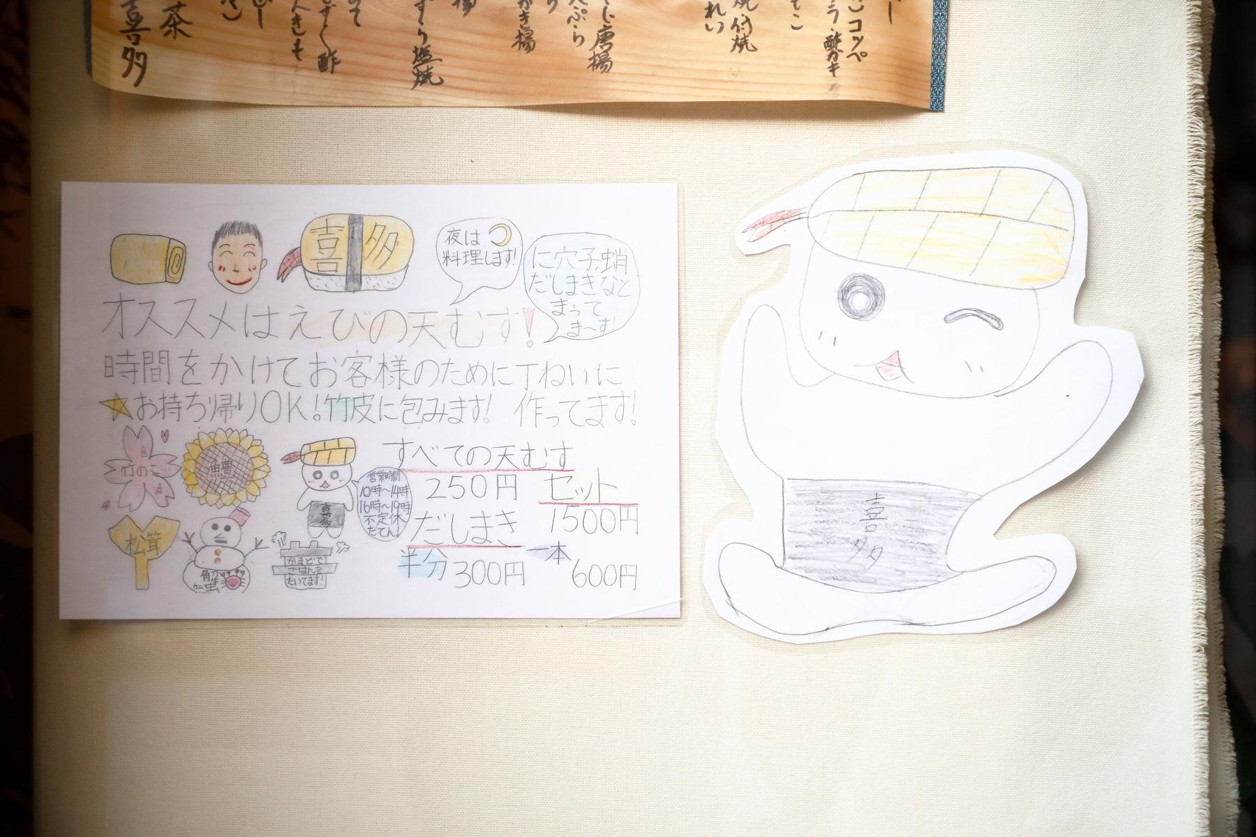 近所の小学校の生徒さんが見学に来て、書いてくれた「天むす 喜多」の紹介。入口すぐの壁に大切そうに貼ってあった。