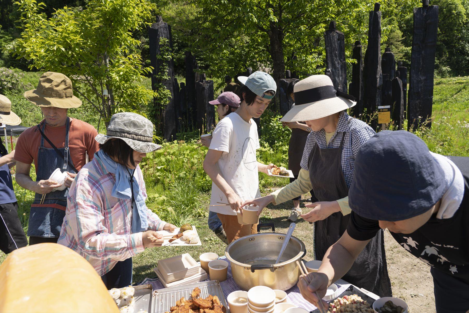 田んぼの上に広がる小高い丘に軽トラックを入れて、荷台に料理を並べ、即席の青空バイキングがスタート!