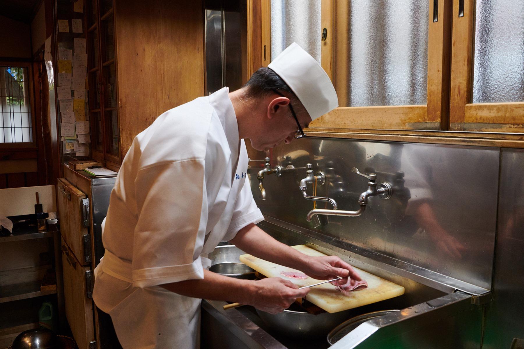 四代目の油井一浩さん。市場を歩いて回り、目当ての鰯を求める。