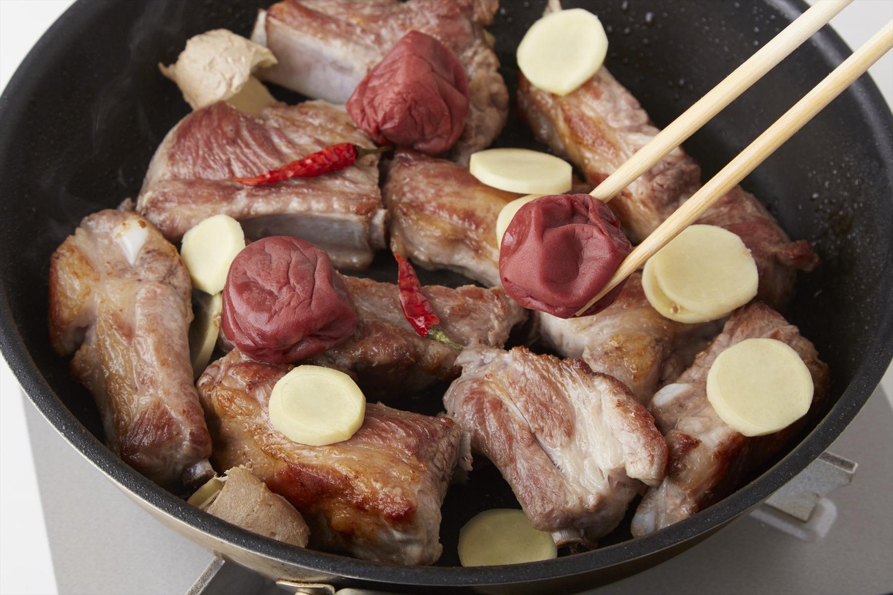 均等に味がいきわたるように、梅干し、生姜などはスペアリブの全体に散らす。蓋をして弱火で40～50分煮る。