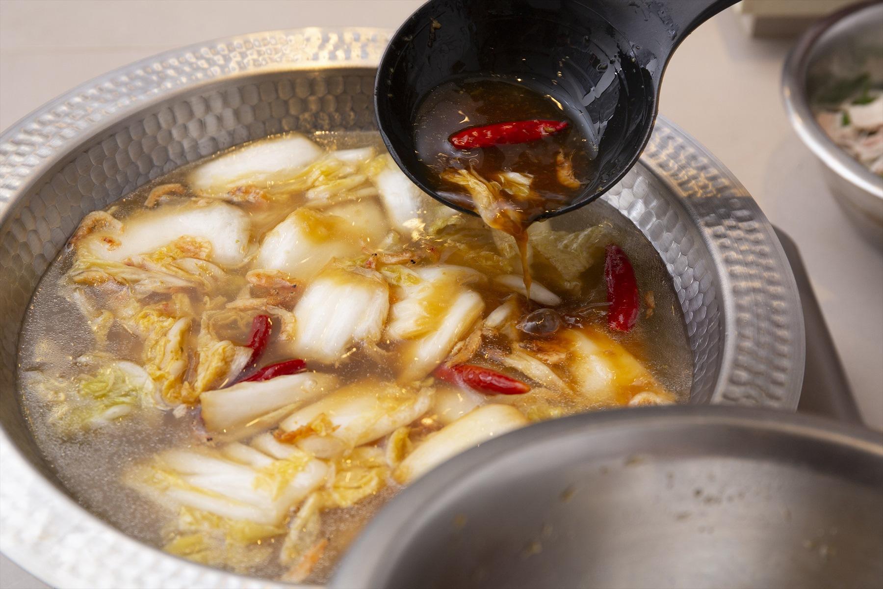 鍋で鶏ガラスープを沸騰させ、具を入れていく