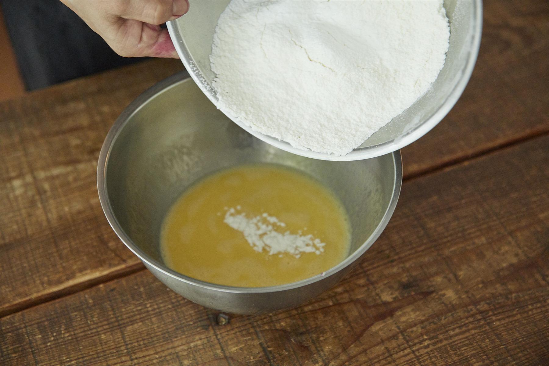 ボウルに卵、オリーブオイル、牛乳を入れて溶きほぐし、ふるった薄力粉とベーキングパウダーを加える