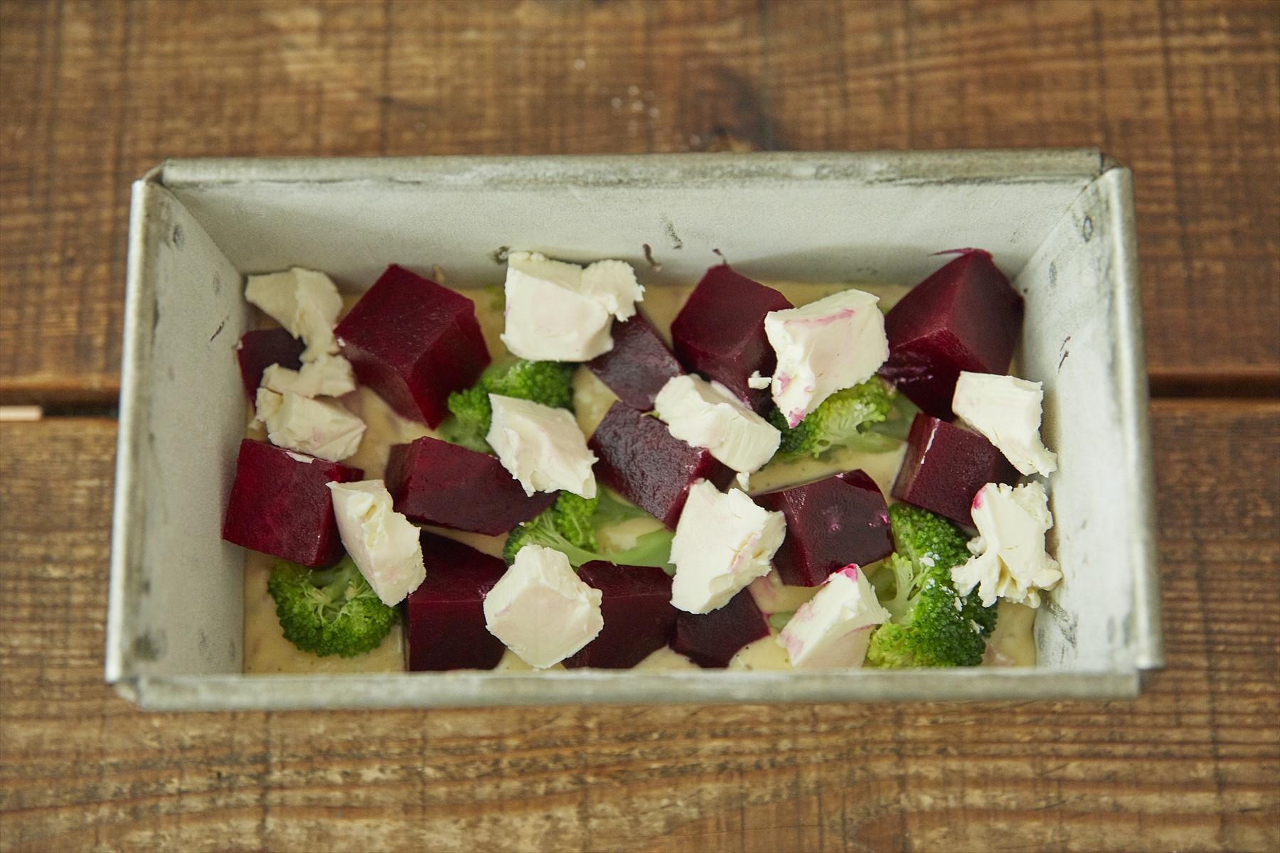 生地の1/3を型に敷き詰め、ビーツ,クリームチーズ、ブロッコリーの半量を散らす