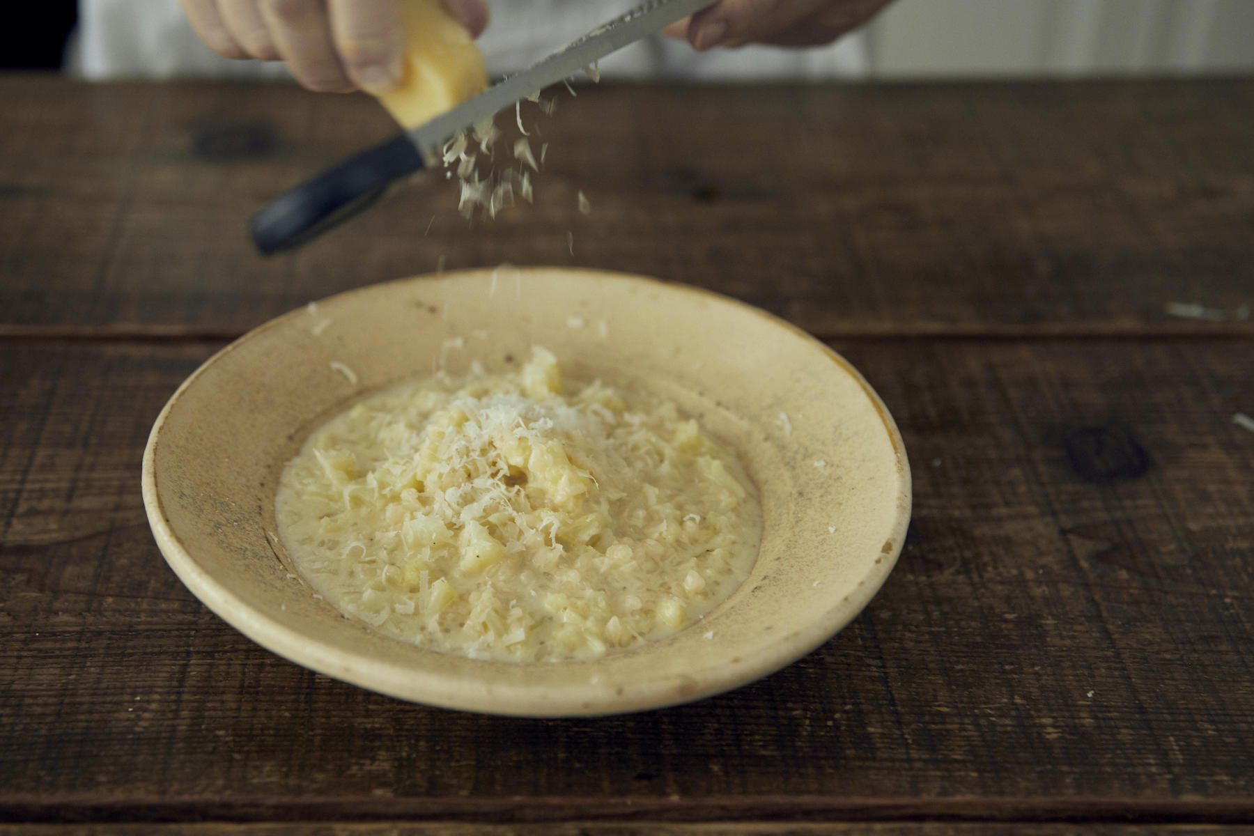 すりおろしたてのパルミジャーノチーズを散らす