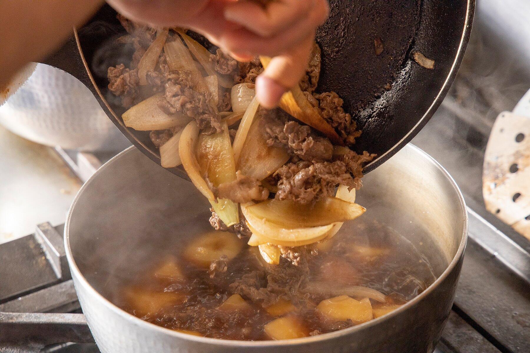 鍋にフライパンの玉ねぎと牛肉、乱切りにしたトマトを加えて7～8分煮る