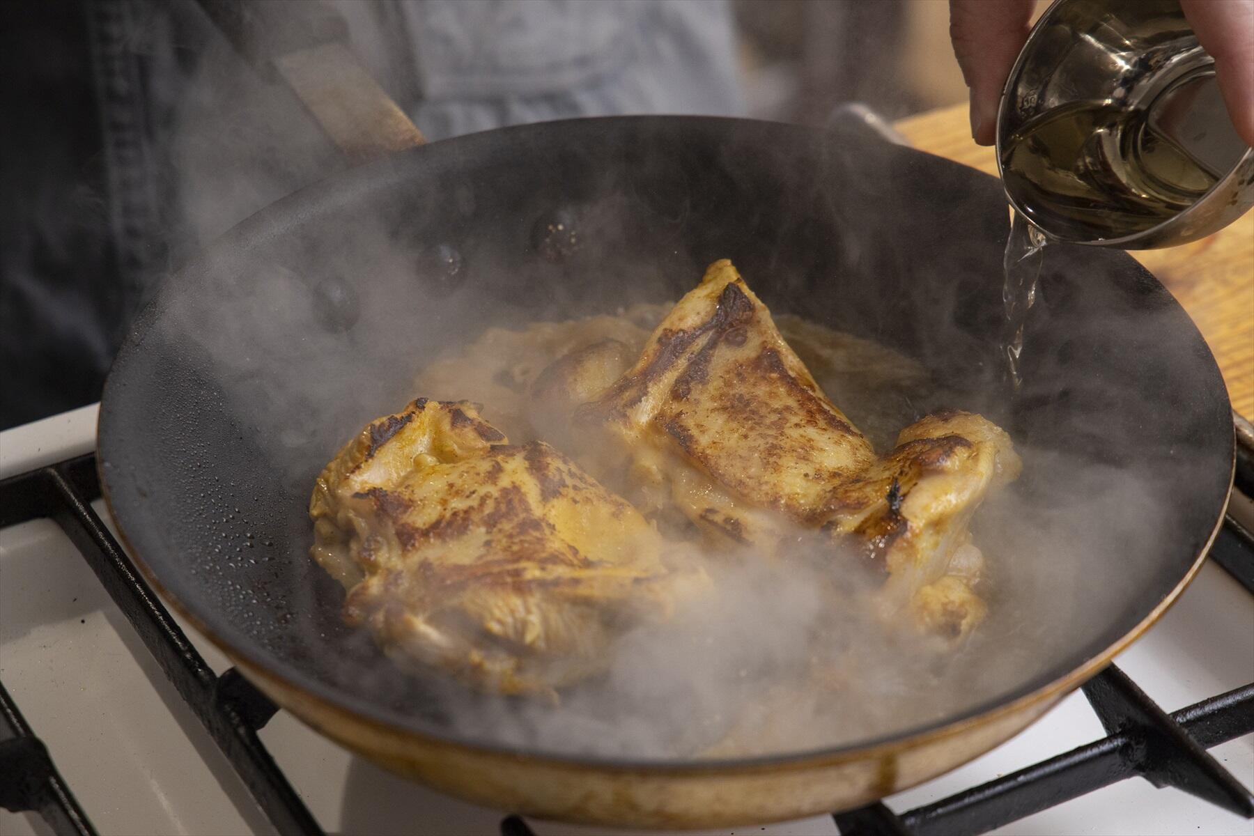 白ワインを注ぎ、蓋をして蒸し焼きにする