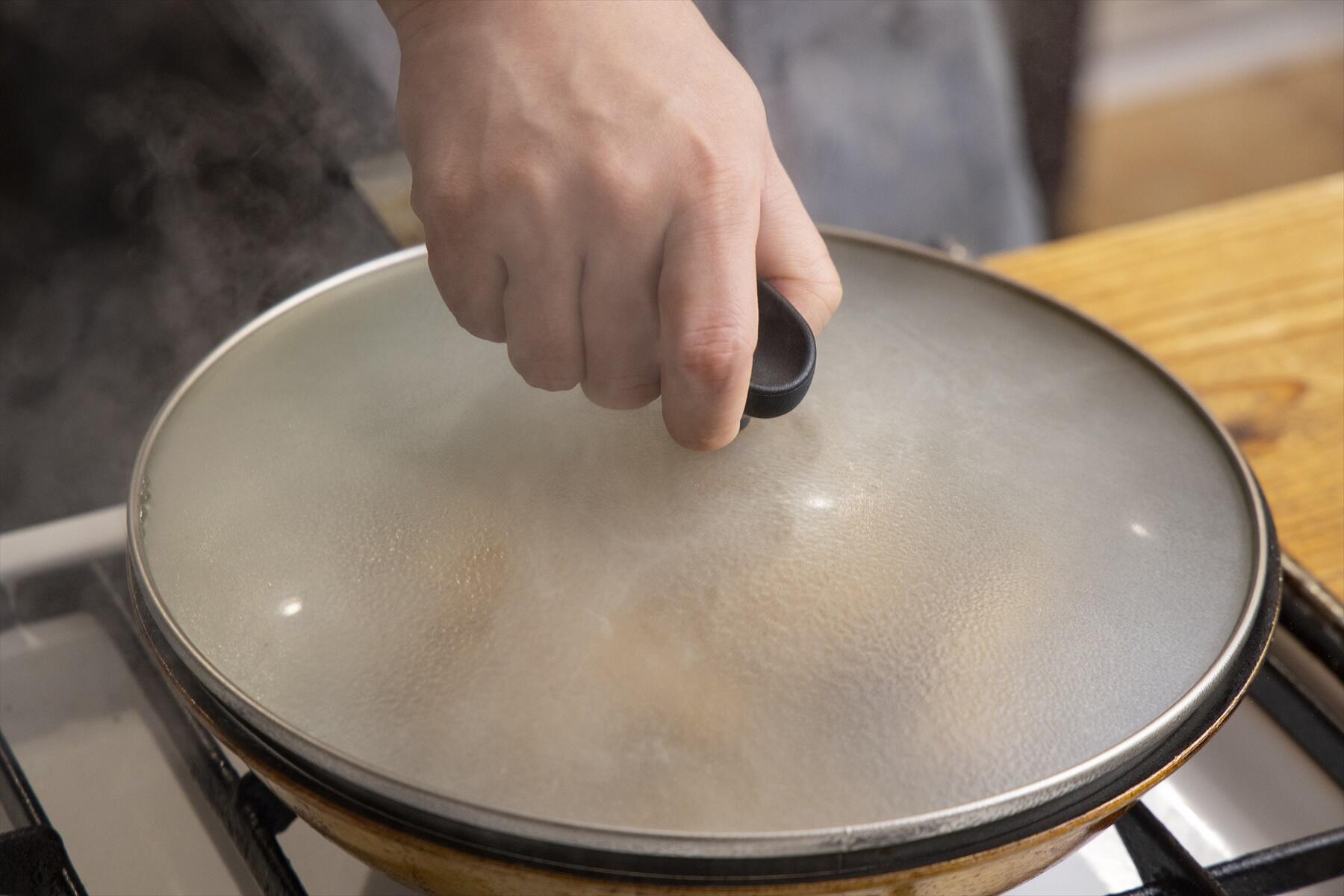 白ワインを注ぎ、蓋をして蒸し焼きにする