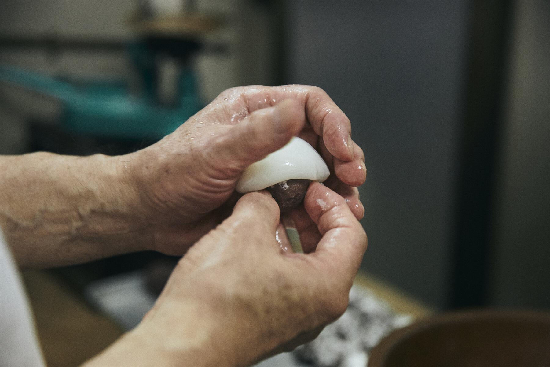 葛の生地を受け取って、餡玉をのせて手早く成形