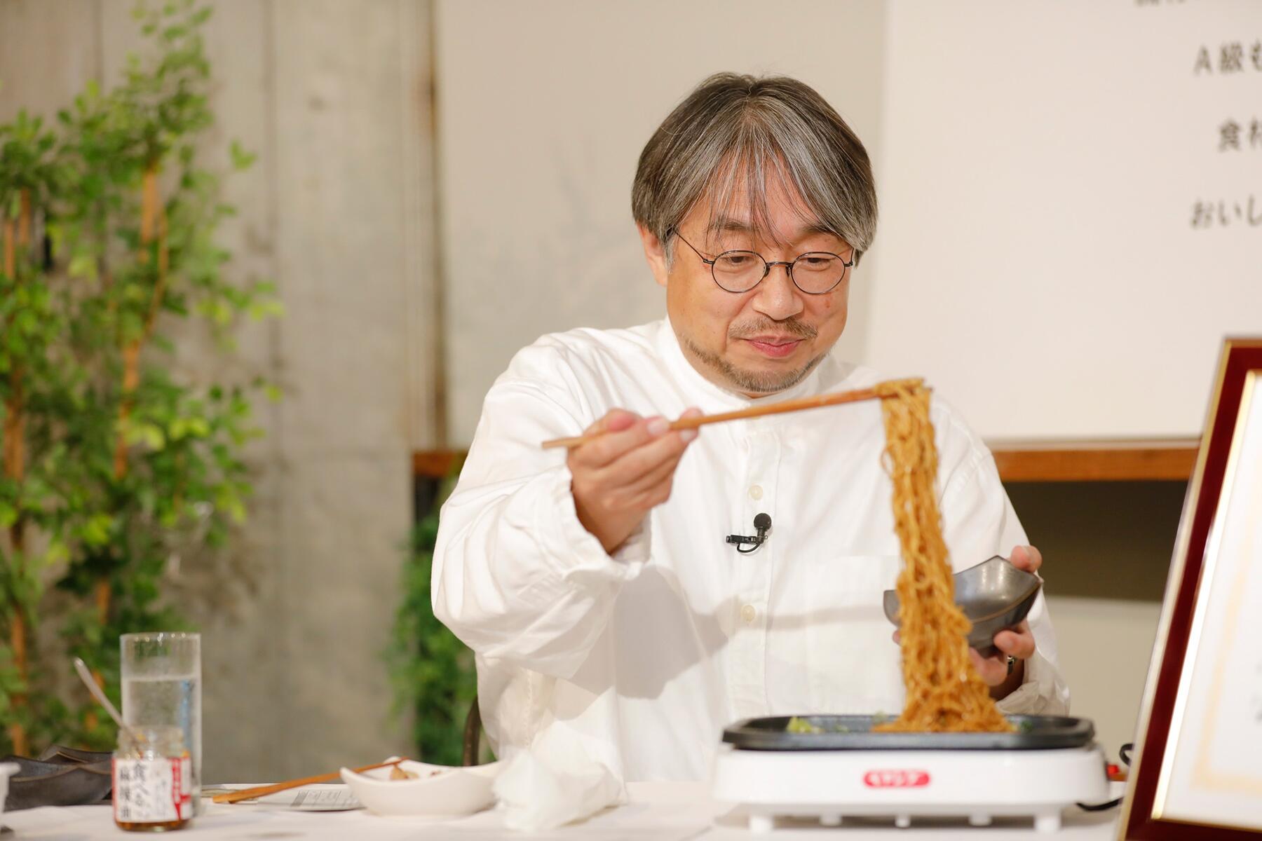 麺を持ち上げる小山薫堂さん