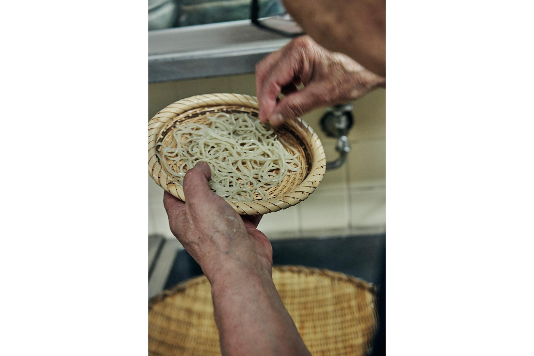 蕎麦のゆで加減を見る男性