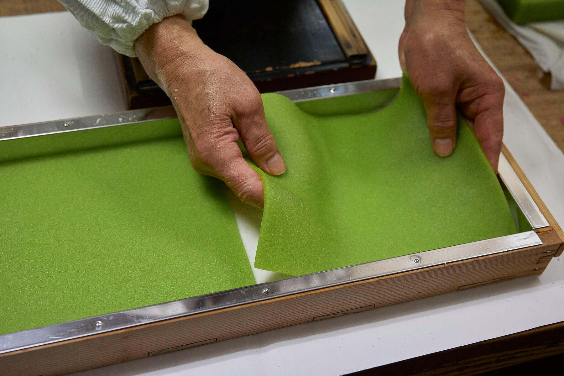 薄く切り出したものを2枚並べて入れると、1枚の羊羹のようにぴたりとはまる。下の白い生地の高さと羊羹の厚み、それぞれが揃っていなければ、真っ直ぐ平らにはならない。手作業でこの精密さ、ということに驚く。