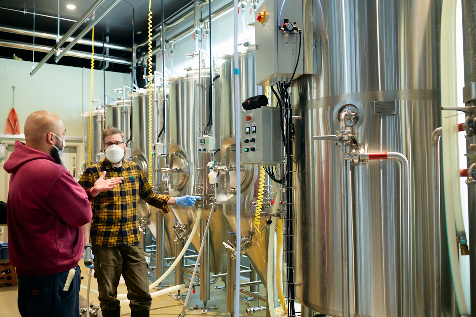 貯蔵タンクとジェームズ・ワトニーさん丹治和也さん