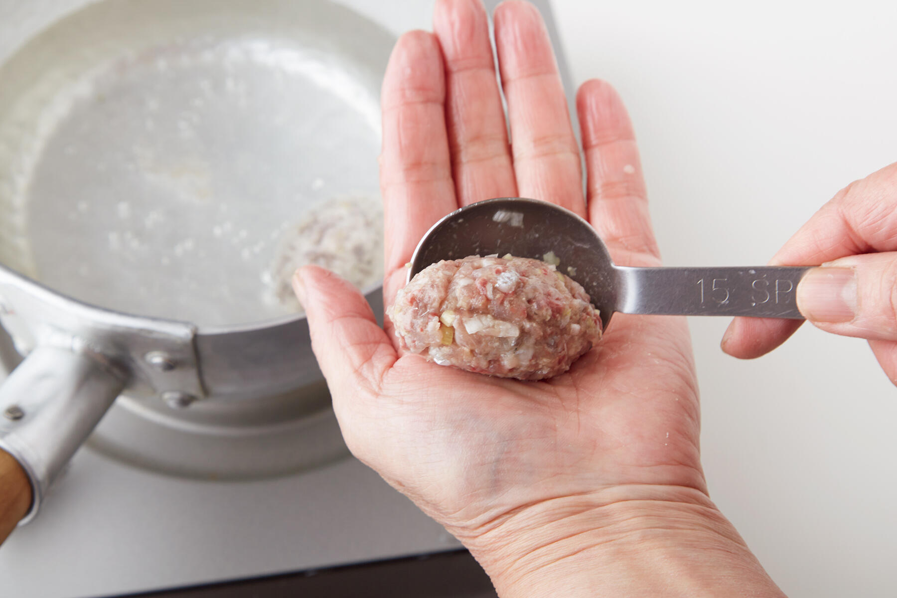 つみれを鍋に落とし入れる