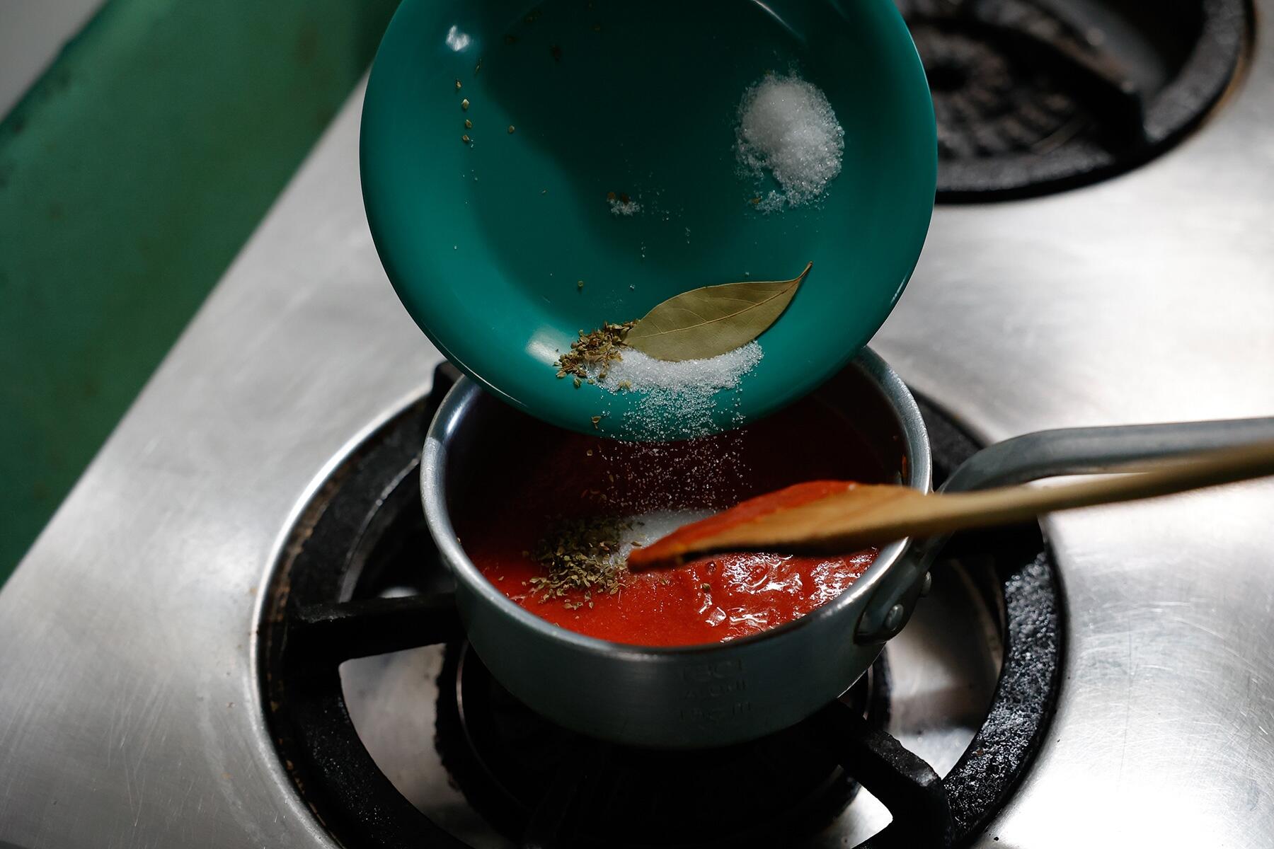 トマト水煮、調味料、ハーブを加えて煮詰める