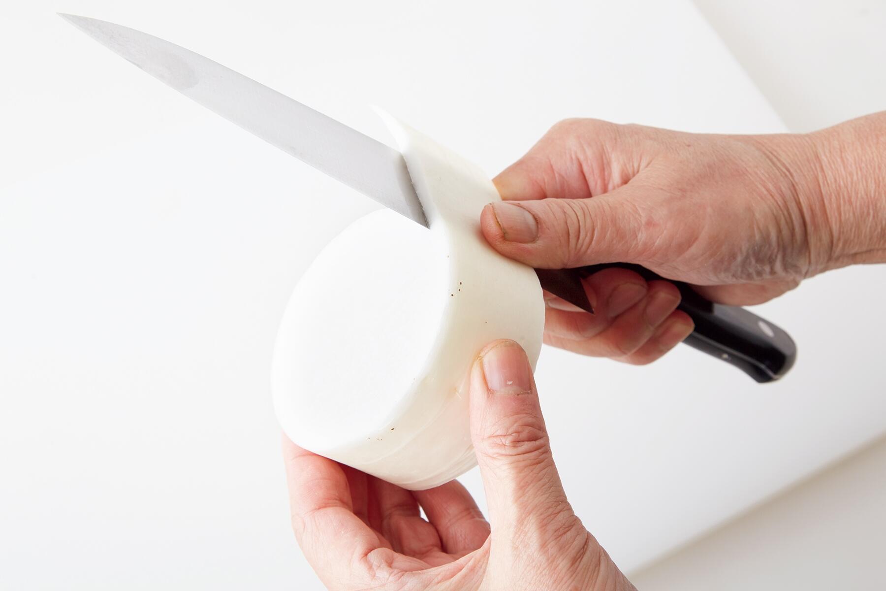 大根の皮をむく