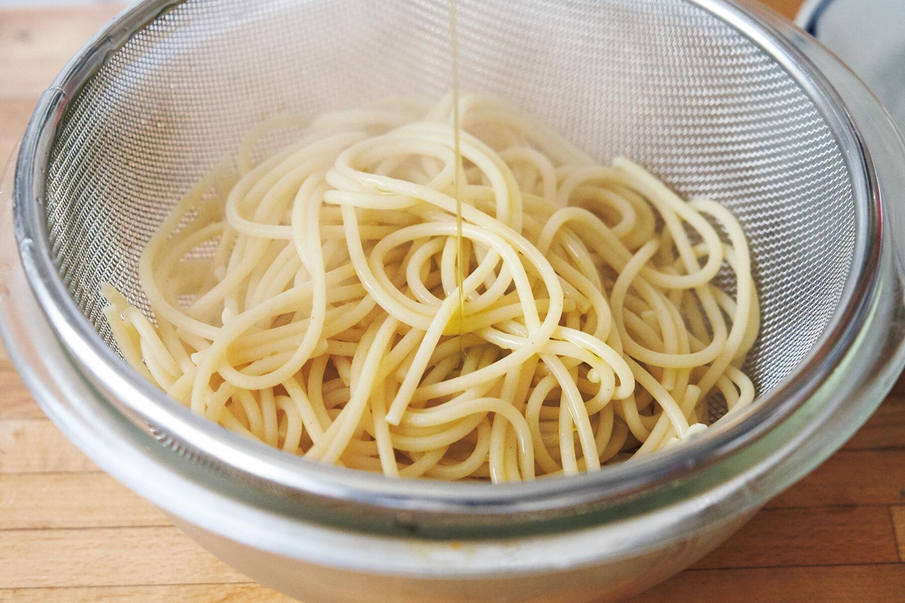 スパゲッティにオイルをまぶす