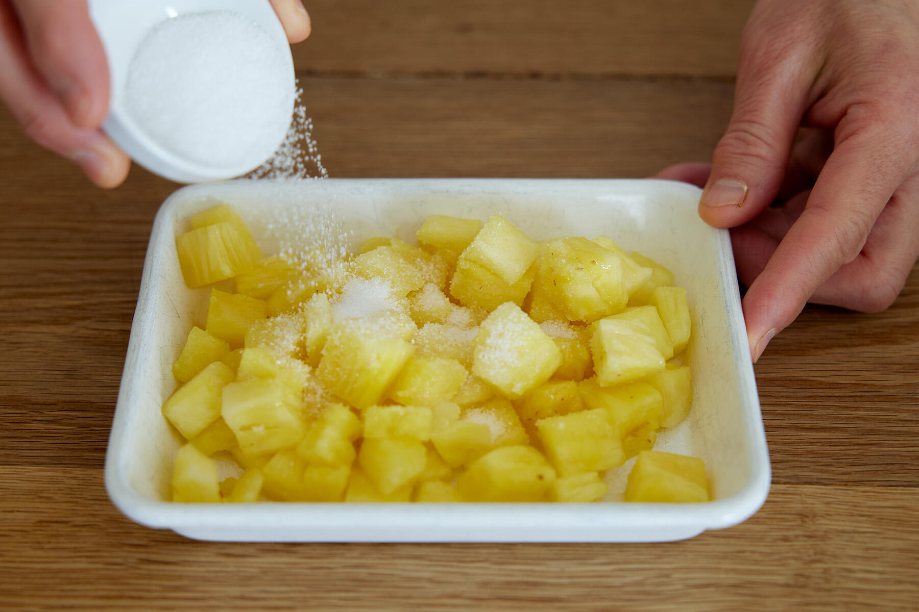 パイナップルにグラニュー糖をまぶす