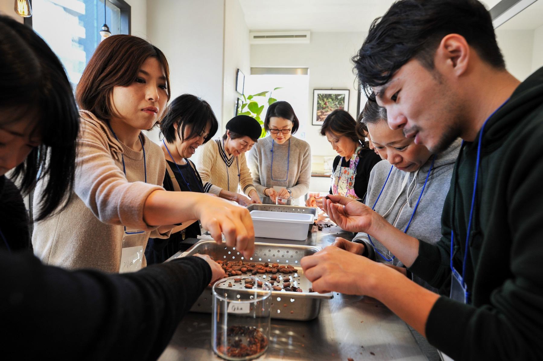 カカオ豆の殻は想像以上に硬い！山下さんの話を聞きながら、黙々と殻をむきつづけます。