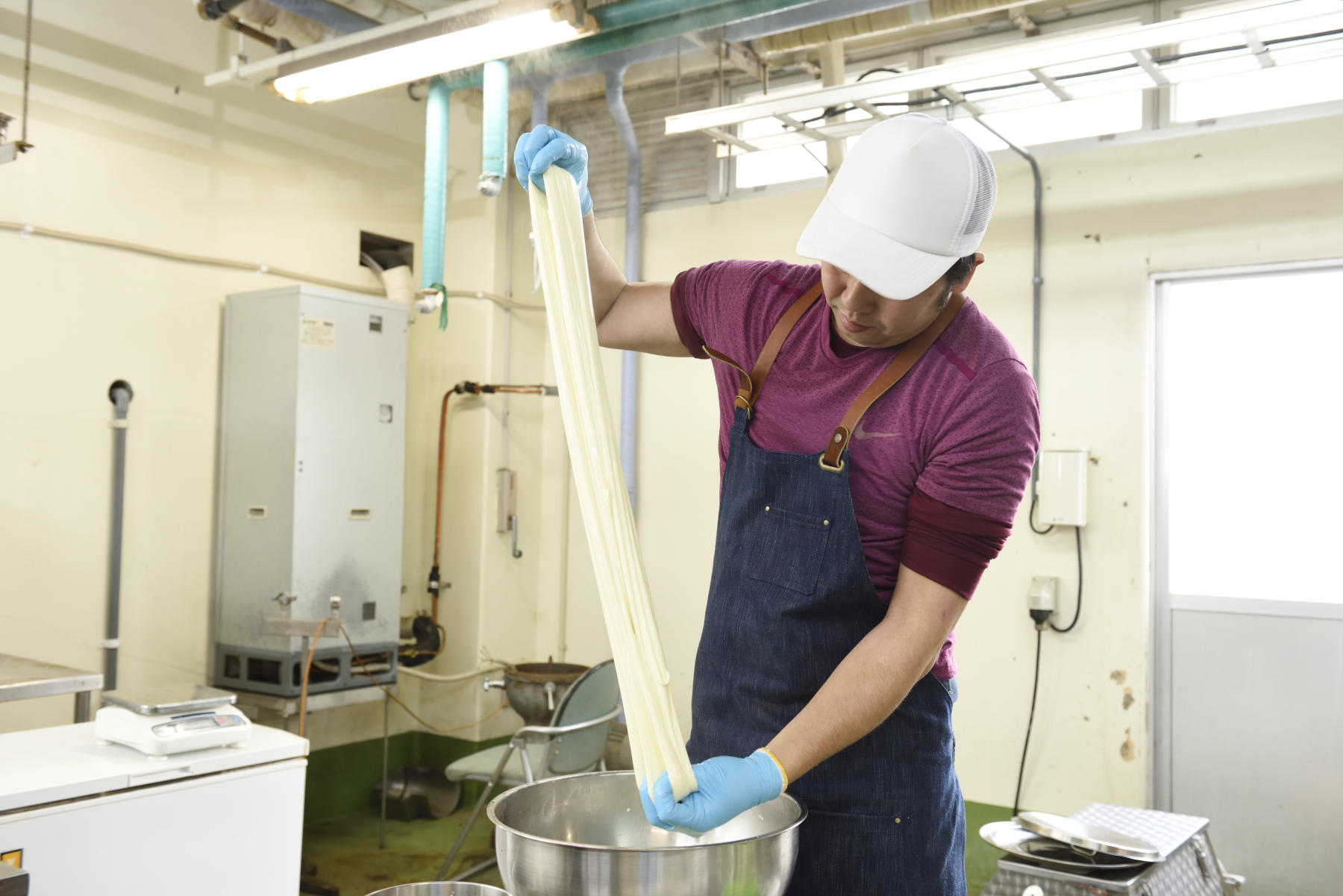 カード(凝乳)を練るうちにツヤツヤと光沢を帯びたモッツァレラチーズに変身していく。