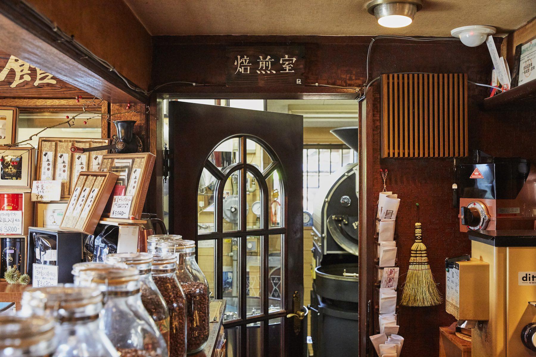 「蘭館」の入口すぐ左の焙煎室。かつて昂さんが入り浸っていたこの場所で、今は息子の田原さんが日夜、珈琲豆と語り合っている。扉の向こうに見えるのはドイツ製のプロバット、右奥にはフジローヤル3kg釜、左奥には井上製作所の12kg釜がある。