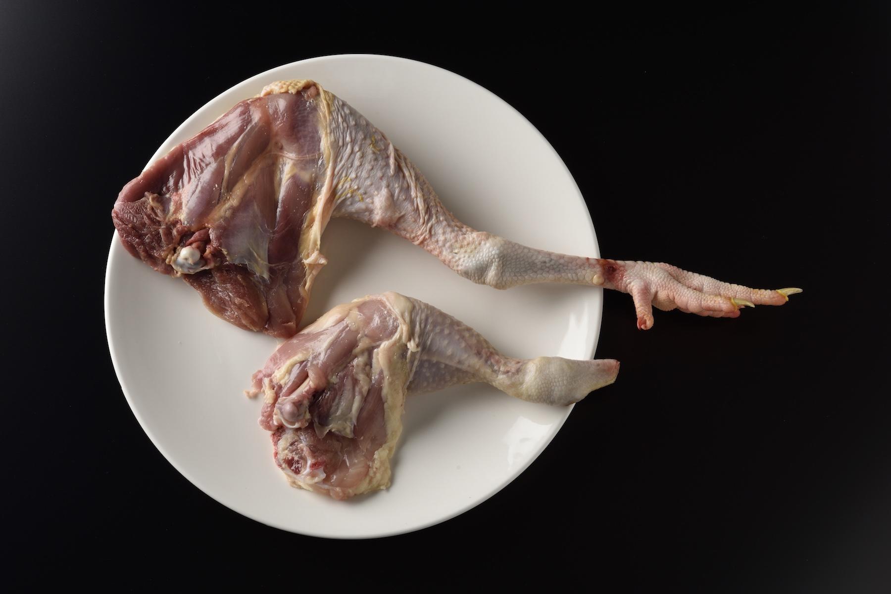 上が「東京しゃも」で下がブロイラー。「東京しゃも」のもも肉は赤身が強く大きい。膝から下、いわゆる「ドラムスティック」の部分のサイズにも違いがある。